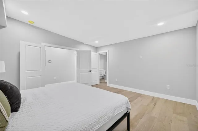 a bedroom with a bed and a painting on the wall