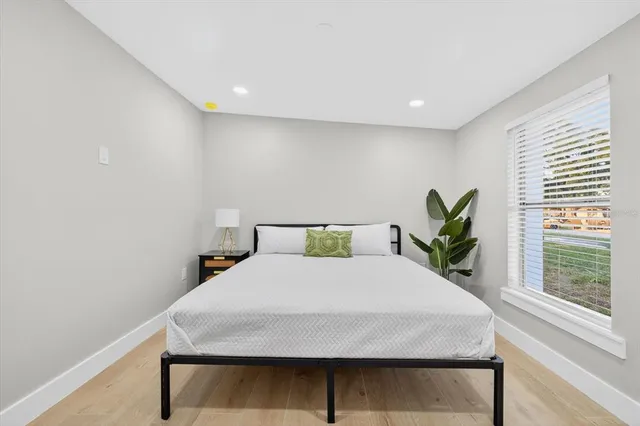 a bedroom with a large bed and a potted plant on table