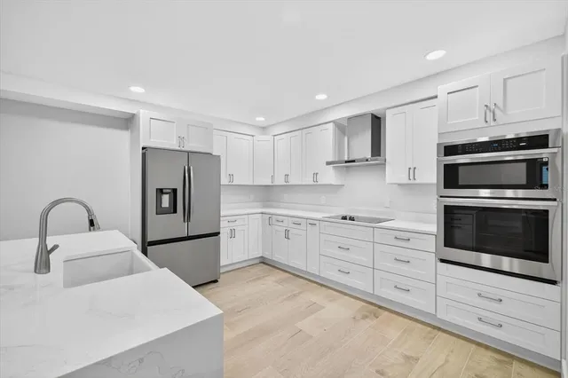 a kitchen with granite countertop white cabinets and stainless steel appliances