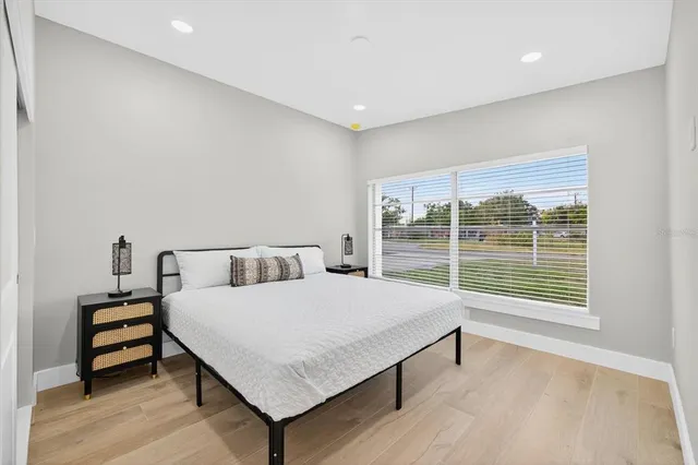 a bedroom with a bed and a large window