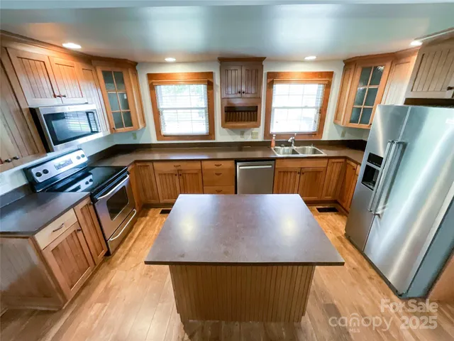 a kitchen with stainless steel appliances granite countertop a sink stove and refrigerator