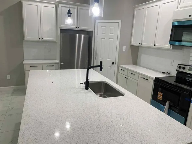 a kitchen with a sink a stove and refrigerator