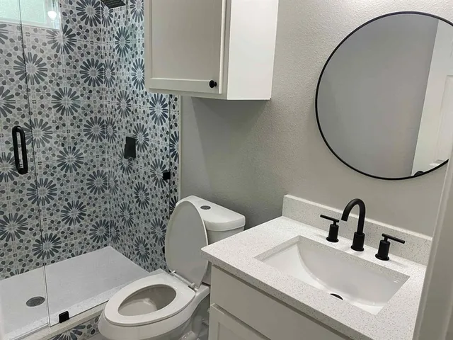 a bathroom with a sink a toilet and a mirror