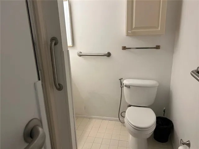 a white toilet sitting next to a shower