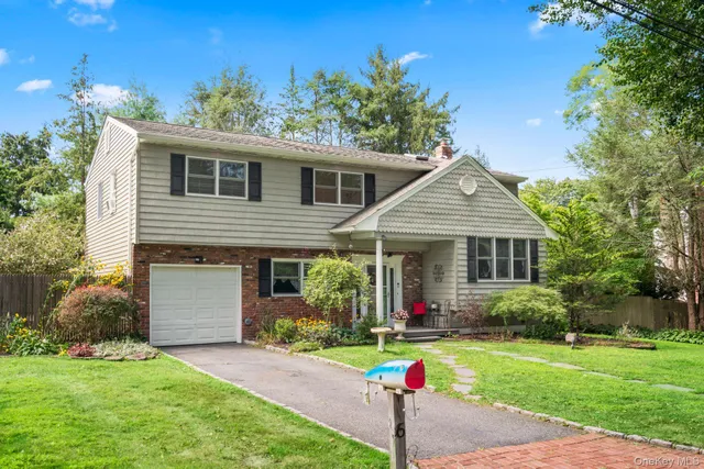 a front view of a house with a yard and potted plants