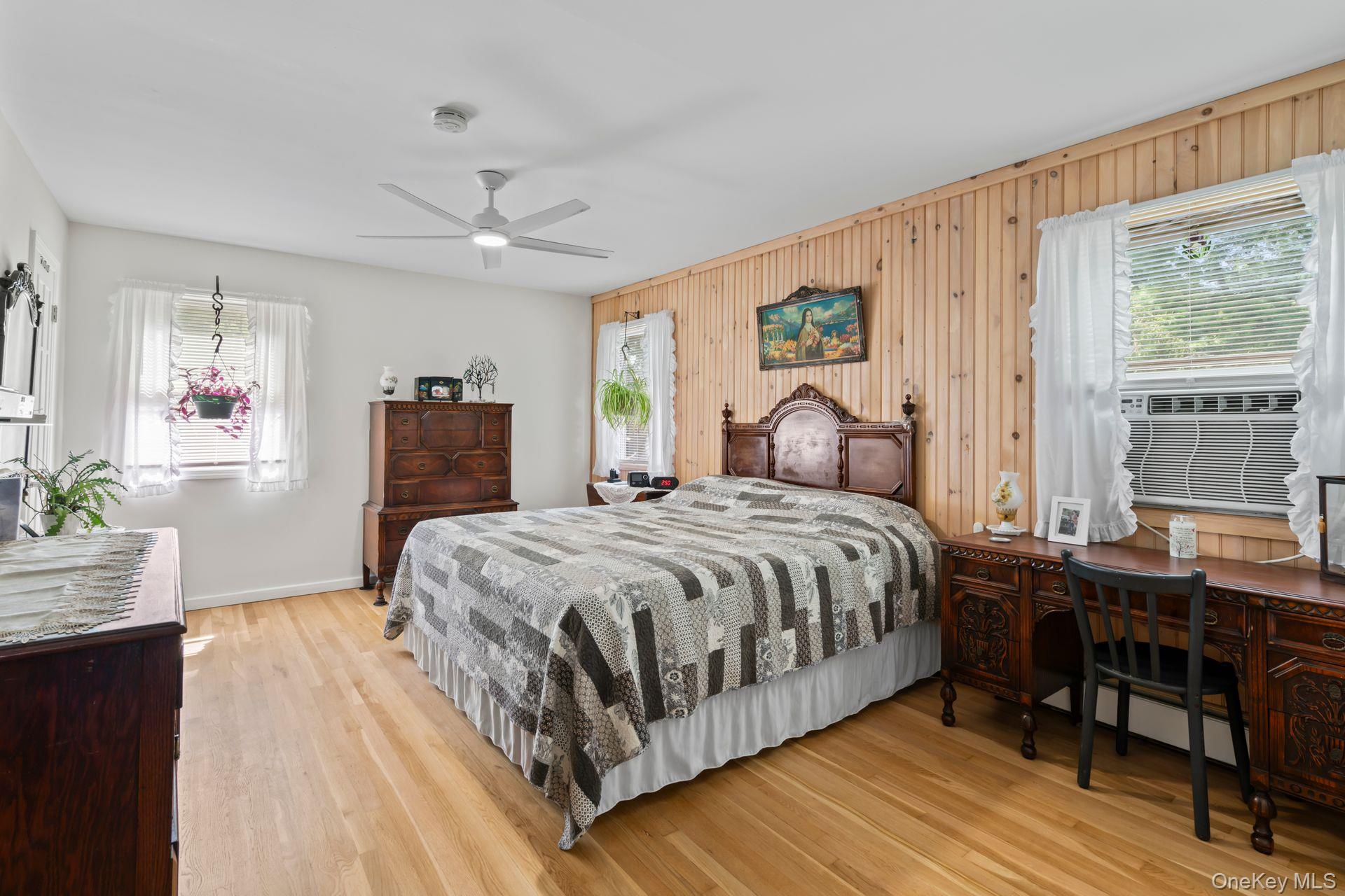 6 Emil Court Huntington, NY 11743 - Photo 14 of 25 a bedroom with a large bed a chandelier and next to a window