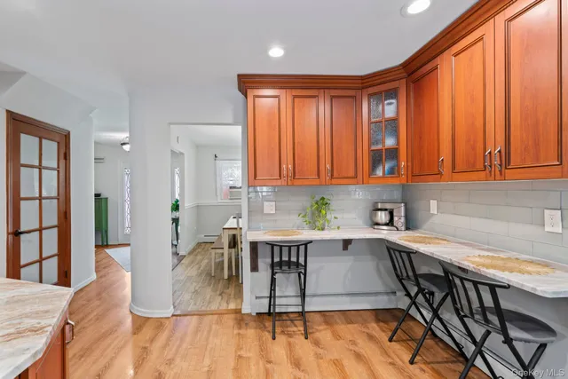 a kitchen with stainless steel appliances granite countertop a table chairs and a wooden floors