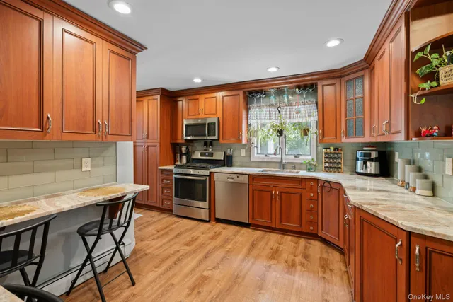 a kitchen with stainless steel appliances granite countertop wooden cabinets a sink and a stove