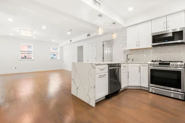 a kitchen with stainless steel appliances a stove top oven a sink and a microwave