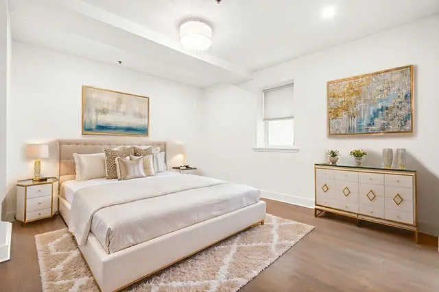 a spacious bedroom with a bed and a painting on the wall