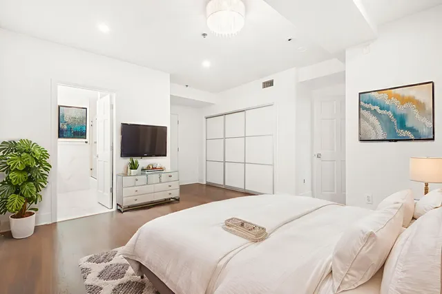 a bedroom with a bed window and flat screen tv