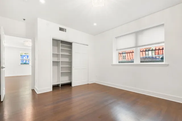 a view of empty room with wooden floor and window