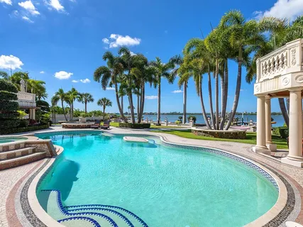 a living room with a black white checkered floor with a gaming machine and dining chairs