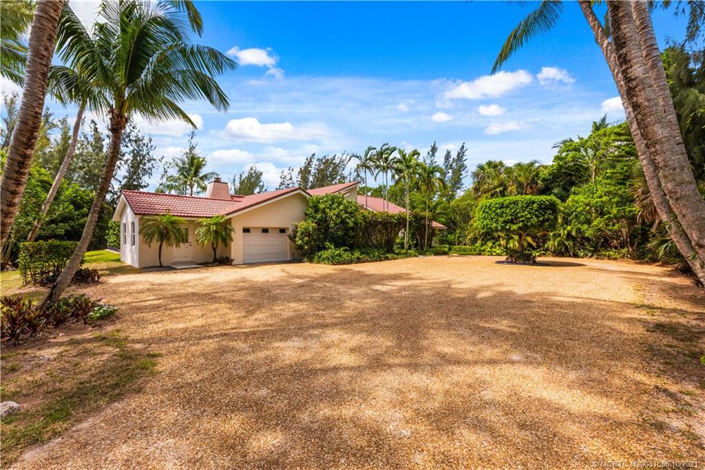 114 North Beach Road Hobe Sound, FL 33455 - Photo 12 of 37 a view of a house with a yard and potted plants