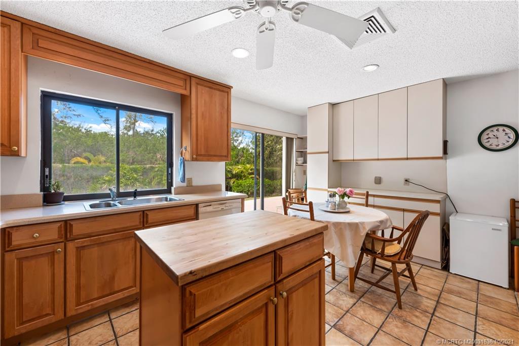114 North Beach Road Hobe Sound, FL 33455 - Photo 22 of 37 a kitchen with a stove a refrigerator and a table