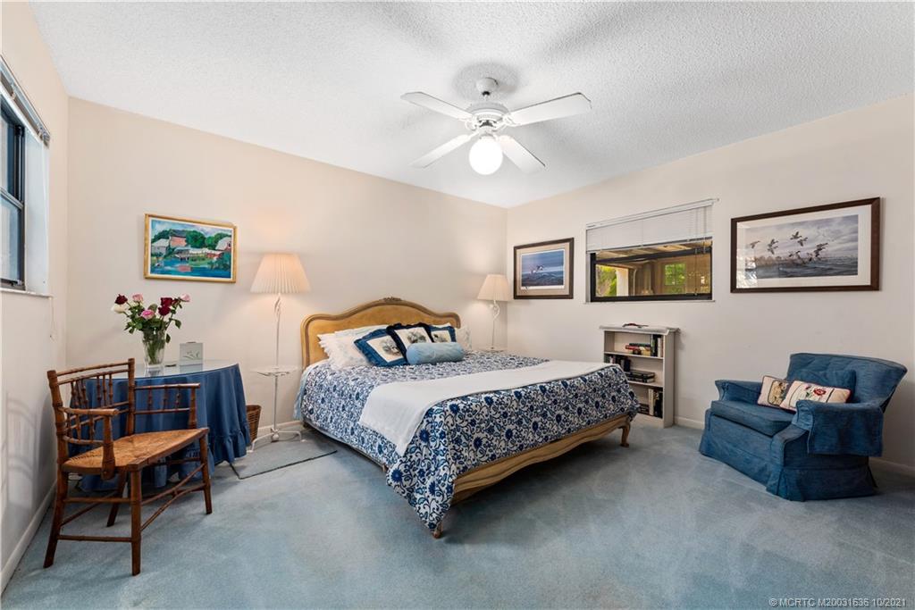 114 North Beach Road Hobe Sound, FL 33455 - Photo 29 of 37 a bedroom with a bed and a chandelier