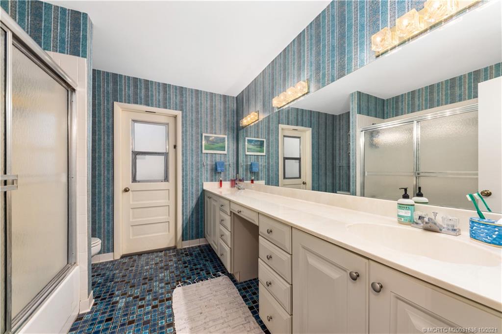 114 North Beach Road Hobe Sound, FL 33455 - Photo 32 of 37 a bathroom with a sink a mirror and a shower