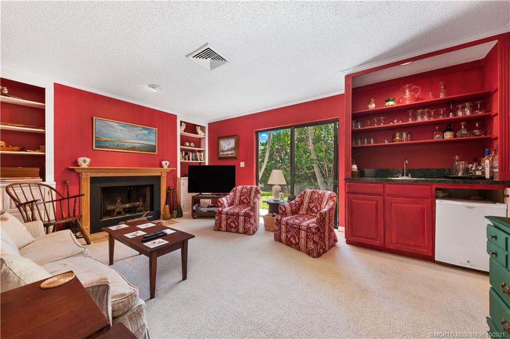 114 North Beach Road Hobe Sound, FL 33455 - Photo 33 of 37 a living room with furniture a fireplace and a flat screen tv