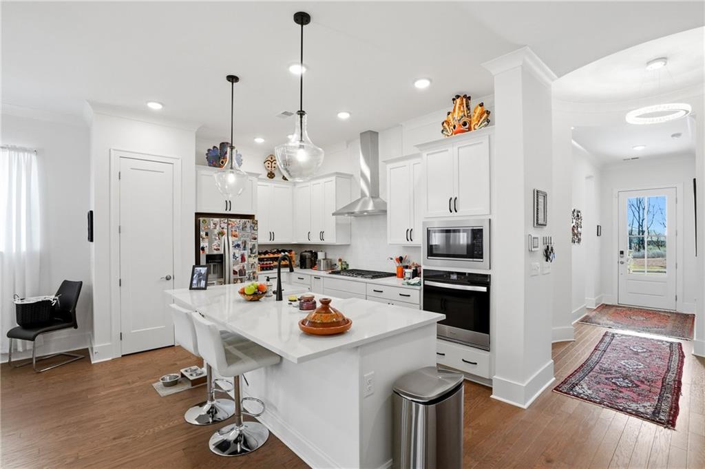 6742 Welcome Road Flowery Branch, GA 30542 - Photo 11 of 48 a kitchen with a refrigerator a stove and white cabinets