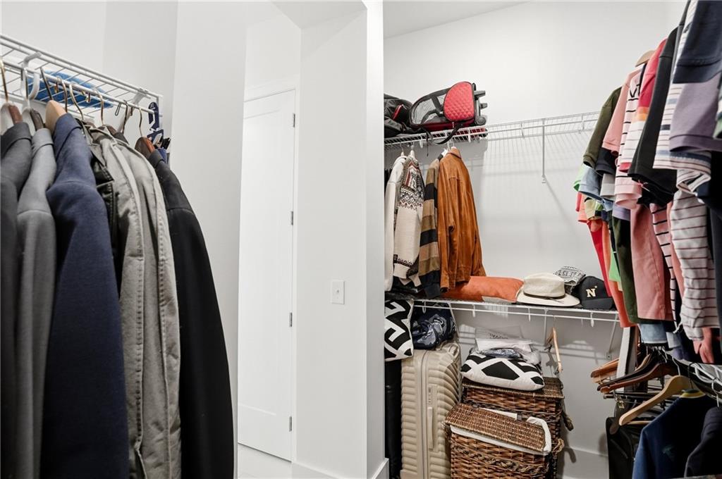 6742 Welcome Road Flowery Branch, GA 30542 - Photo 22 of 48 a view of walk in closet with clothes and shoes