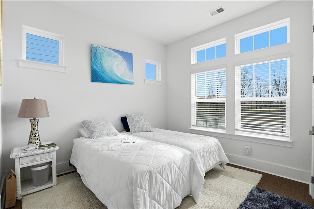 6742 Welcome Road Flowery Branch, GA 30542 - Photo 25 of 48 a bedroom with a bed and a lamp on dresser