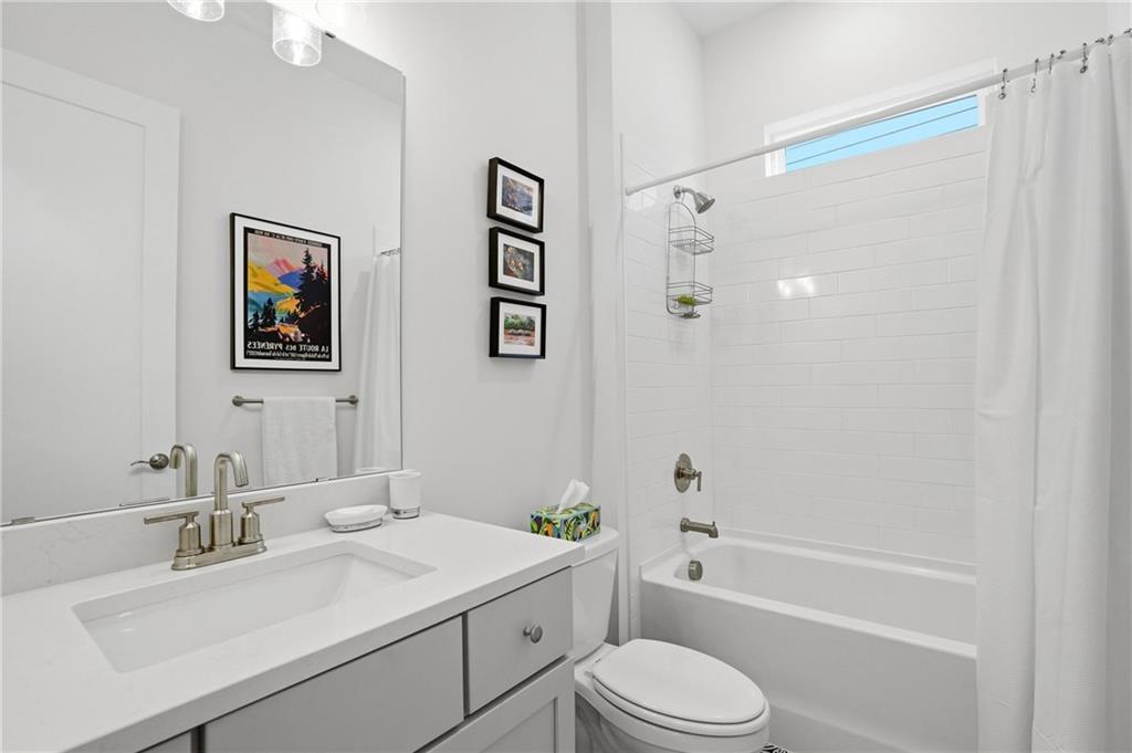 6742 Welcome Road Flowery Branch, GA 30542 - Photo 26 of 48 a bathroom with a granite countertop sink toilet and shower