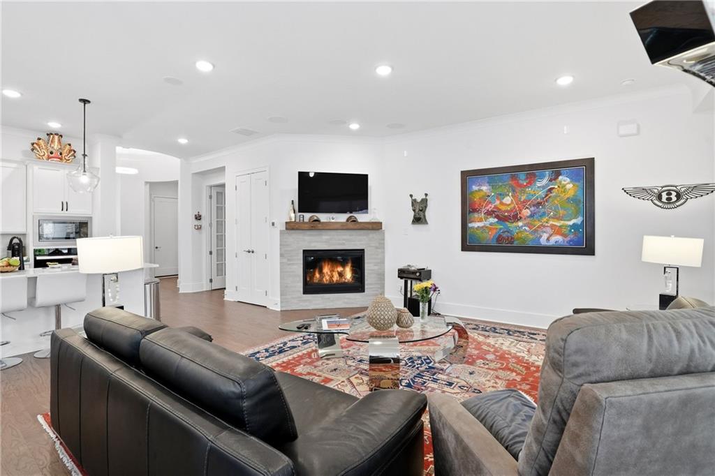 6742 Welcome Road Flowery Branch, GA 30542 - Photo 7 of 48 a living room with furniture fireplace and a flat screen tv