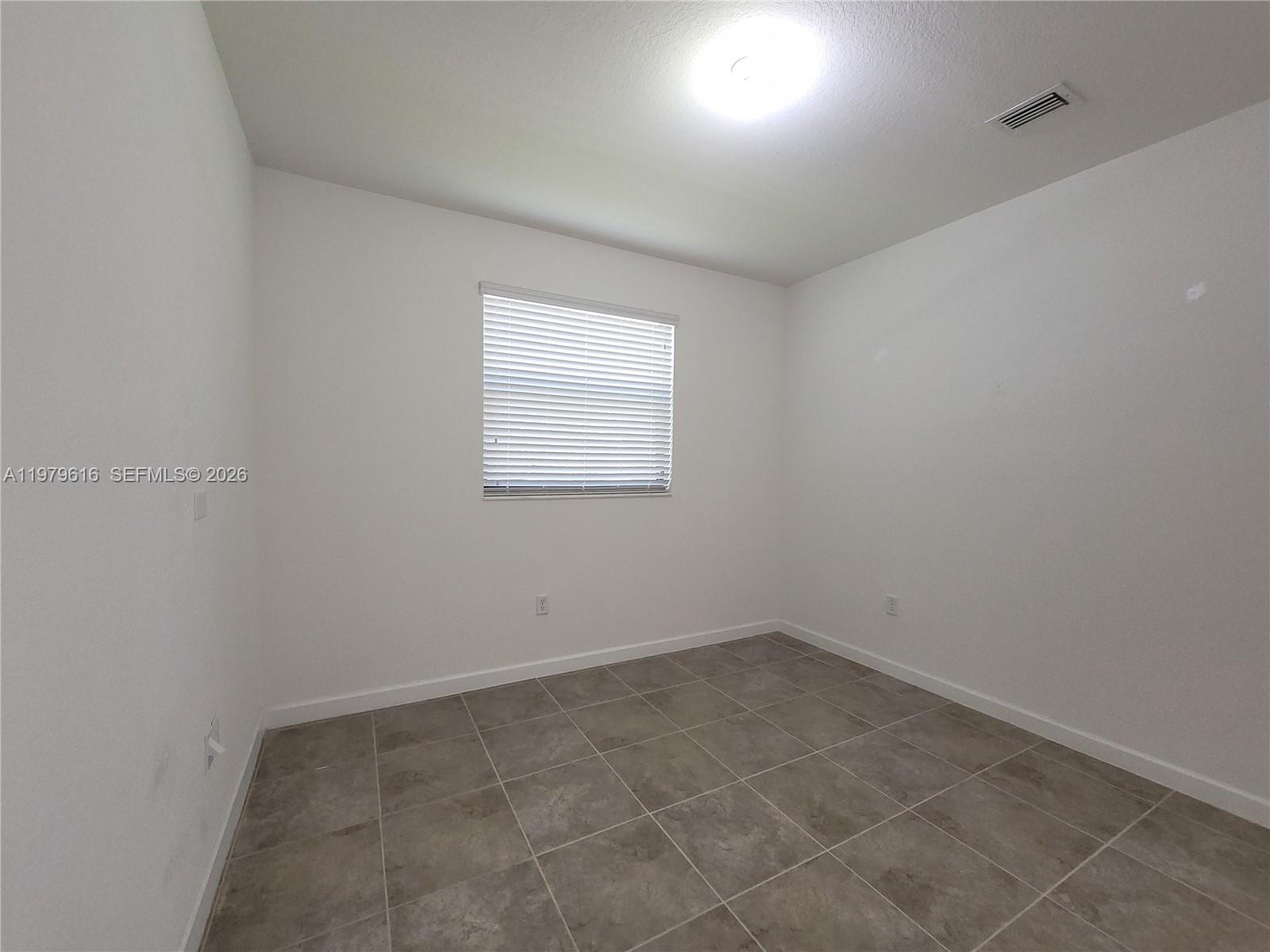 25039 Southwest 114th Avenue Homestead, FL 33032 - Photo 11 of 45 an empty room with a window