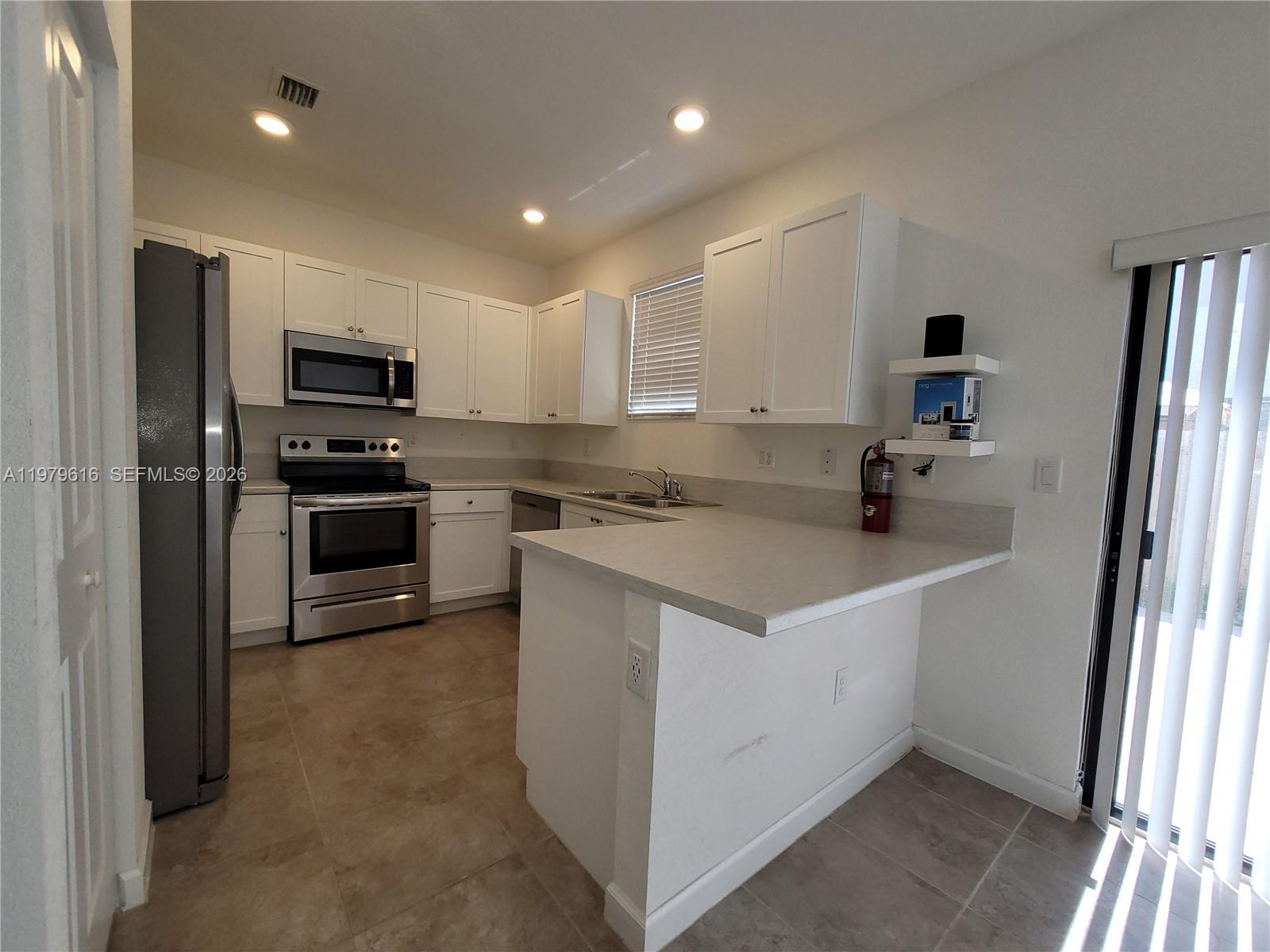 25039 Southwest 114th Avenue Homestead, FL 33032 - Photo 3 of 45 a kitchen that has a sink and a stove top oven
