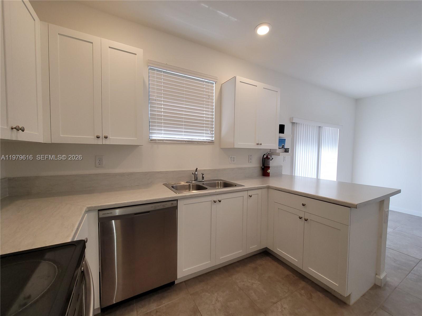 25039 Southwest 114th Avenue Homestead, FL 33032 - Photo 4 of 45 a kitchen with a sink cabinets and window