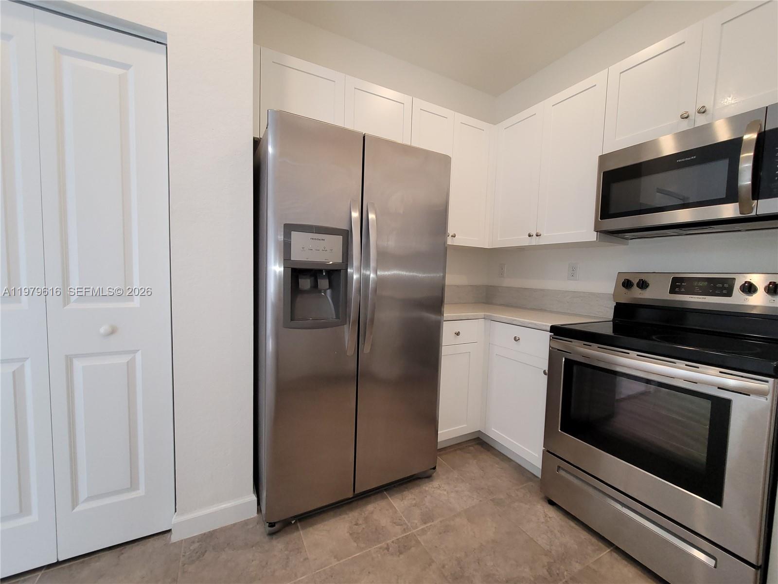 25039 Southwest 114th Avenue Homestead, FL 33032 - Photo 6 of 45 a kitchen with stainless steel appliances granite countertop a refrigerator and a stove top oven