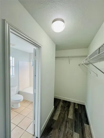 a view of a room with wooden floor and a ceiling fan