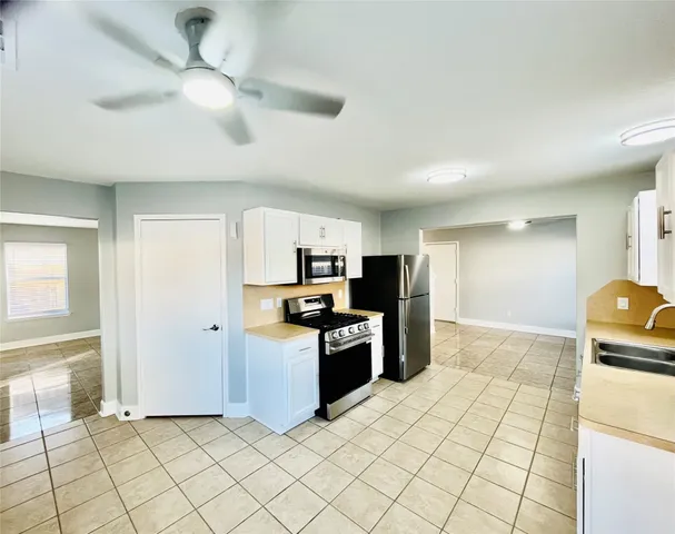 a kitchen with granite countertop a refrigerator and a stove top oven