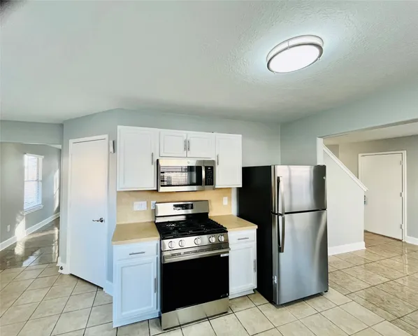 a kitchen with stainless steel appliances a refrigerator a stove a microwave a sink and cabinets