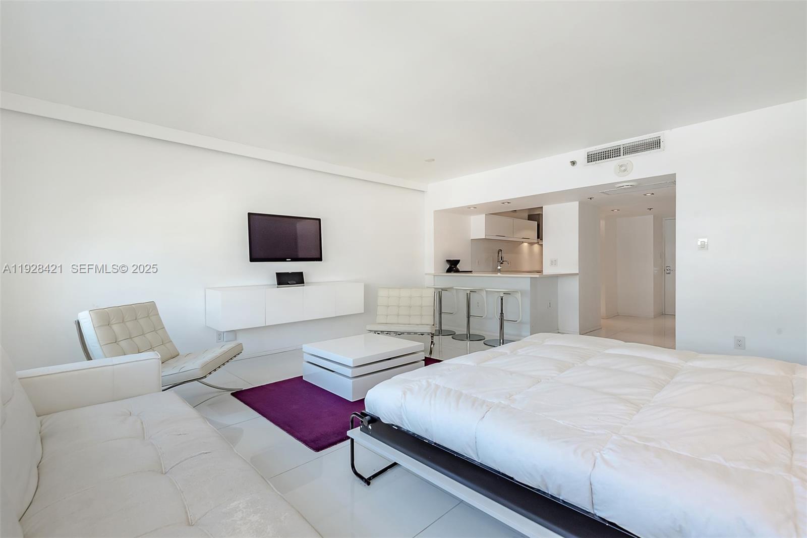 100 Lincoln Road, Unit 839 Miami Beach, FL 33139 - Photo 19 of 26 a spacious bedroom with a bed and a flat screen tv