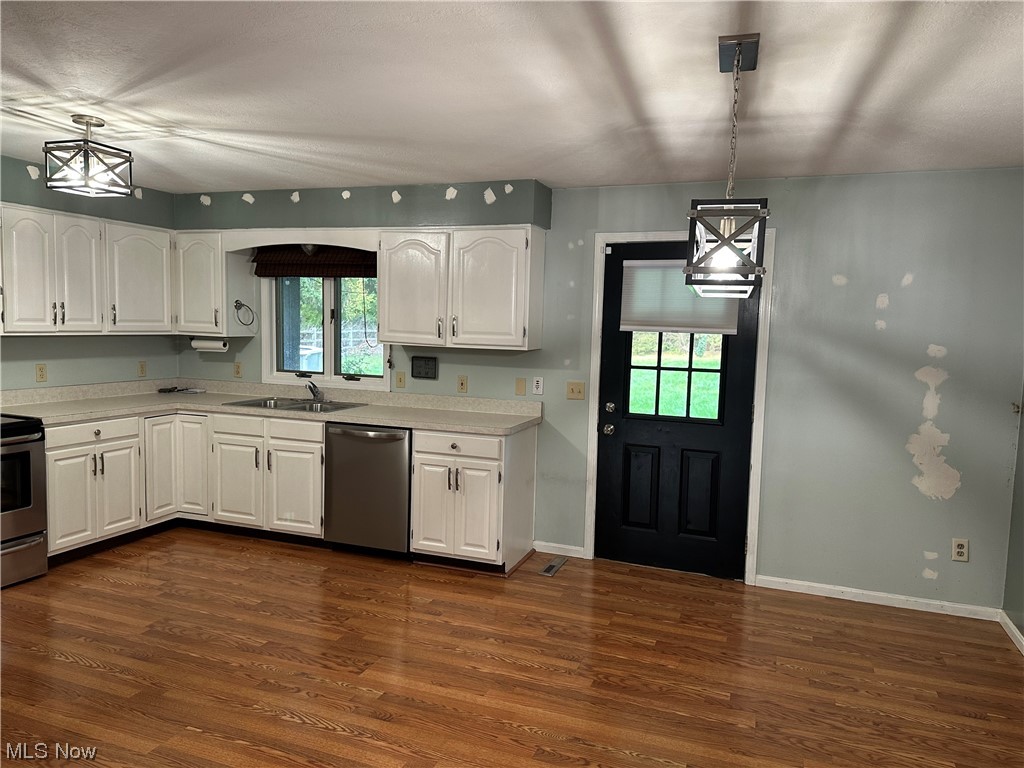 6715 Crosse Road Amherst, OH 44001 - Photo 3 of 21 Kitchen with dark hardwood flooring, white cabinets, and hanging light fixtures