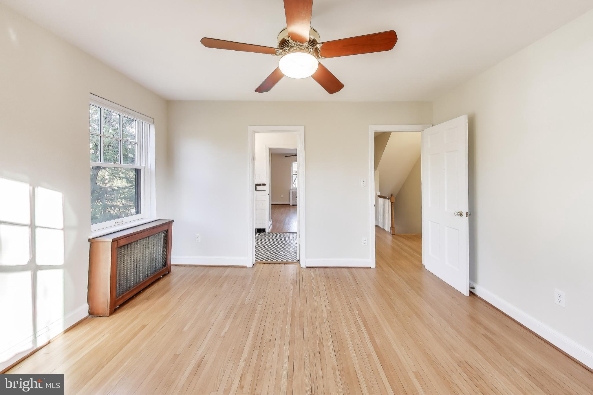 9214 Kingsbury Drive Silver Spring, MD 20910 - Photo 29 of 67 an empty room with wooden floor chandelier fan and windows