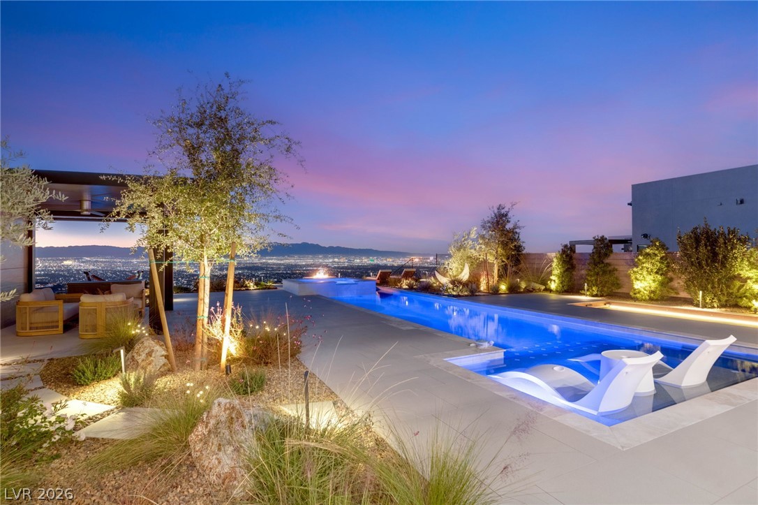 571 Overlook Rim Drive Henderson, NV 89012 - Photo 66 of 85 Pool at dusk featuring an outdoor pool, a hot tub, and a patio