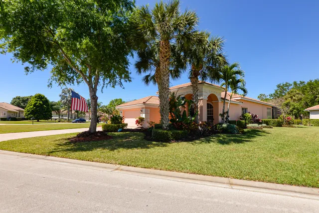 a view of swimming pool with lawn chairs under an umbrella