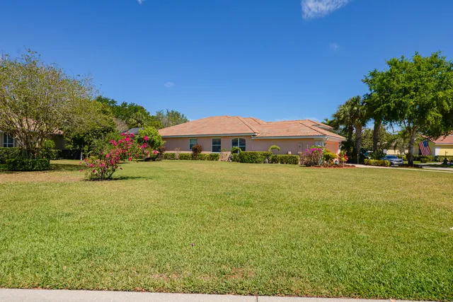 a view of swimming pool that has lawn chairs and a dining table under an umbrella