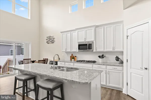 a kitchen with stainless steel appliances granite countertop a sink stove and cabinets