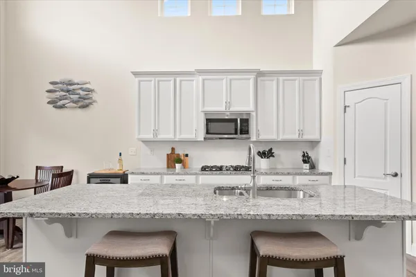 a kitchen with granite countertop white cabinets and stove
