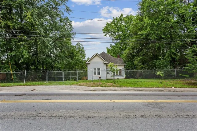 a view of a house in a big yard with large trees