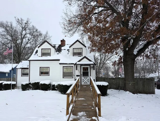 a front view of a house with a yard covered in snow