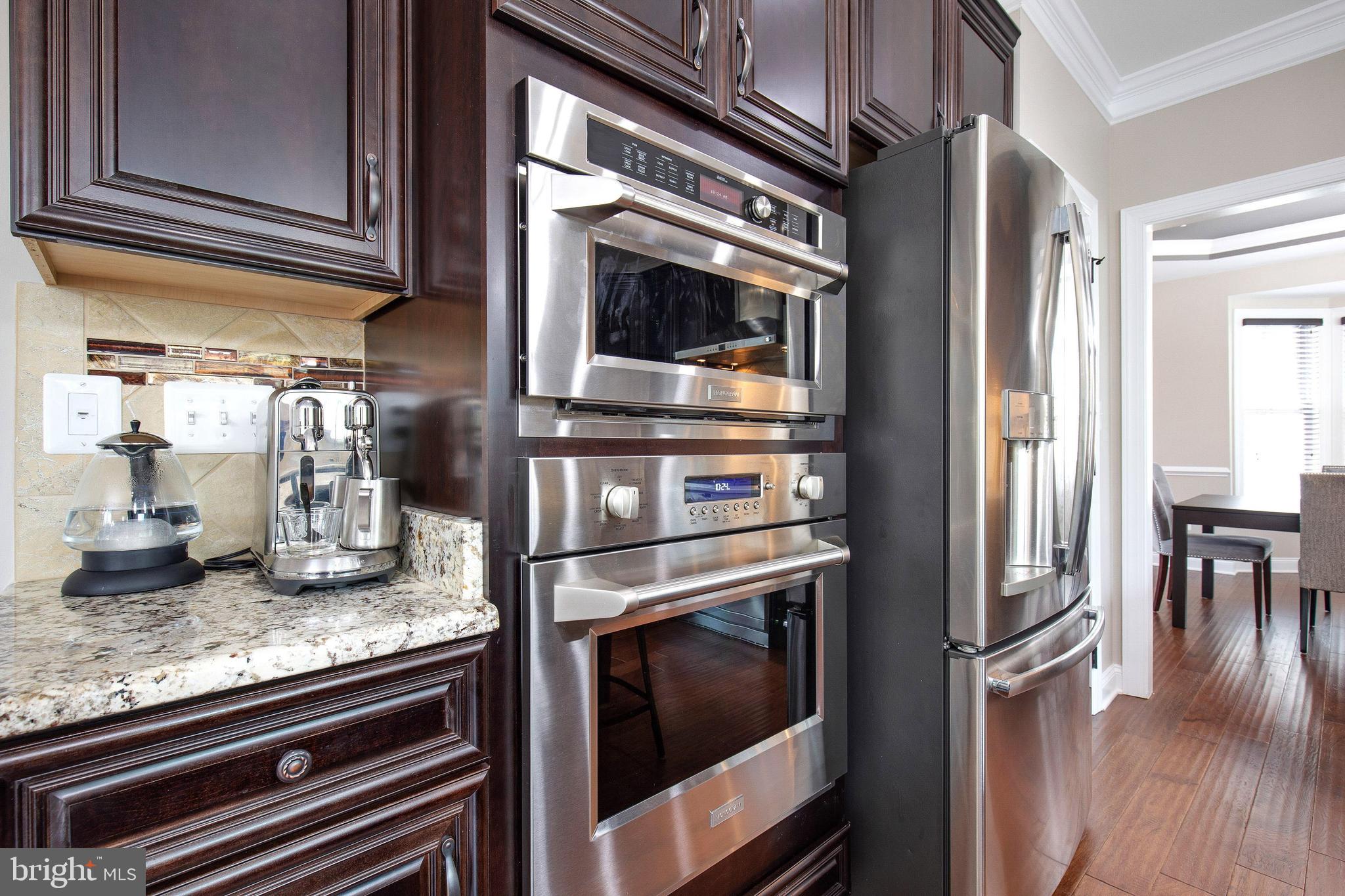 4201 Rolling Paddock Drive Upper Marlboro, MD 20772 - Photo 21 of 62 a kitchen with granite countertop stainless steel appliances and wooden floor