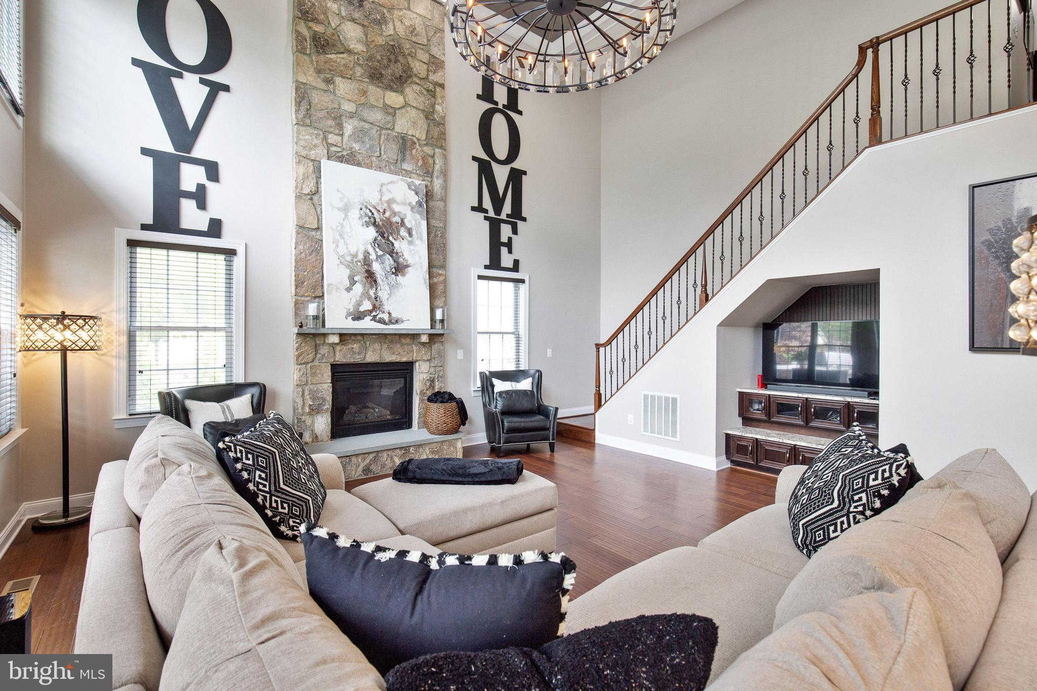 4201 Rolling Paddock Drive Upper Marlboro, MD 20772 - Photo 28 of 62 a living room with furniture a fireplace and a chandelier