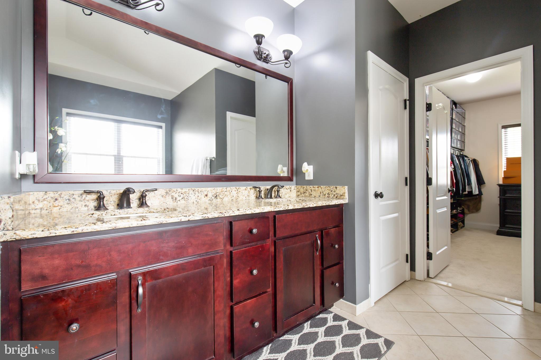 4201 Rolling Paddock Drive Upper Marlboro, MD 20772 - Photo 36 of 62 a bathroom with a granite countertop sink and a mirror