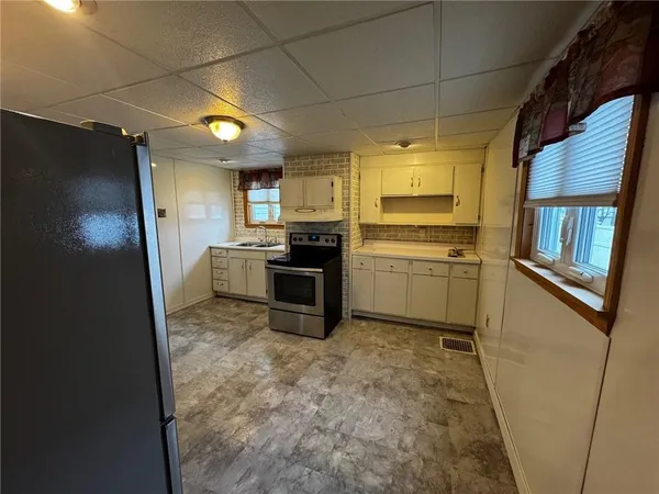 a kitchen with stainless steel appliances granite countertop a refrigerator a stove and a sink