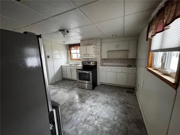 a kitchen with stainless steel appliances granite countertop a refrigerator a stove and a sink