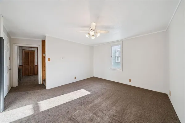 an empty room with fan and windows